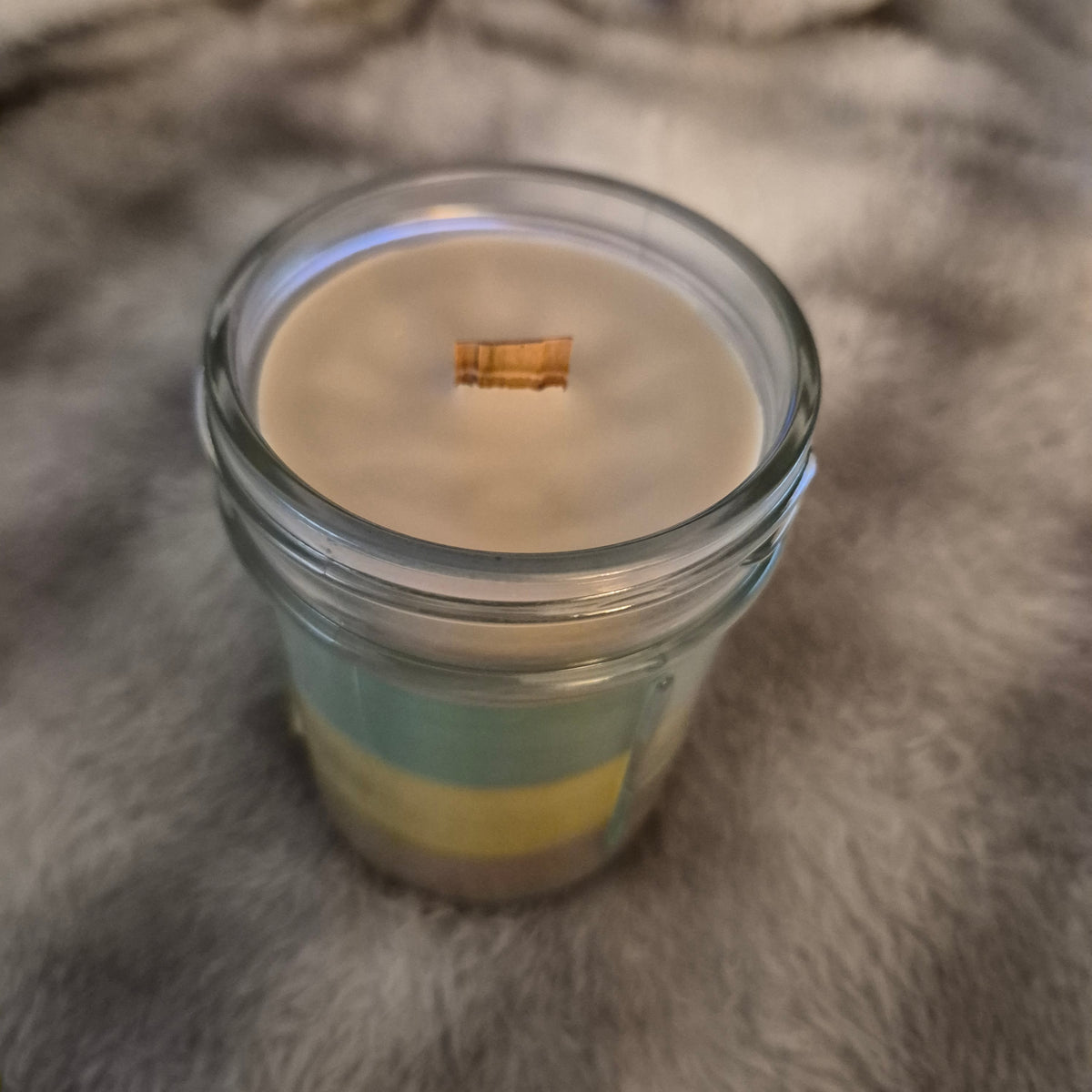 Top view of open 9oz Monkey Farts hand-poured candle in mason jar with wood wick, light green wax layers by Delightful Little Things"